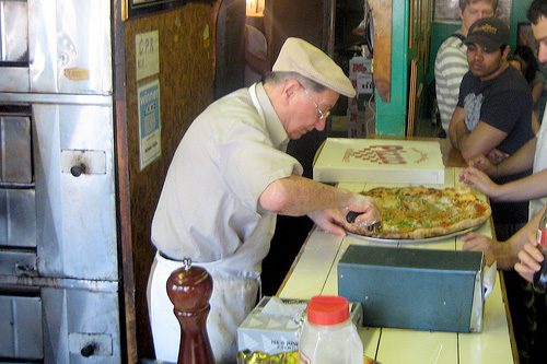 A classic pose of Difar founder Dom DeMarco snipping fresh basil on a newly baked pizza