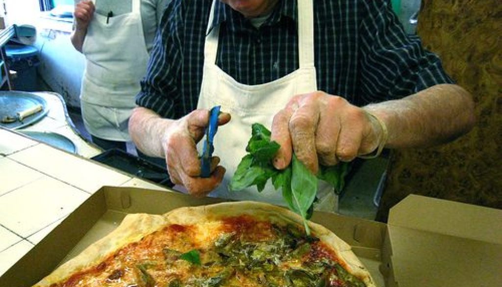 A hallmark of modern pizza started at DiFara, snipping fresh basil on the pie as soon as it comes out of the oven.